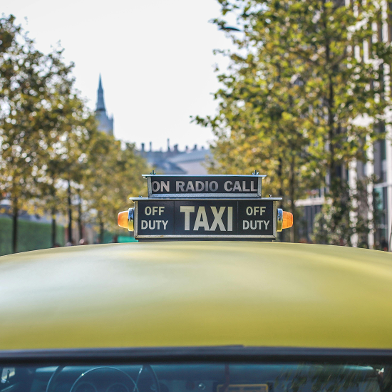Yellow taxi cab with an 'On Radio Call' sign on its roof, seen from the interior